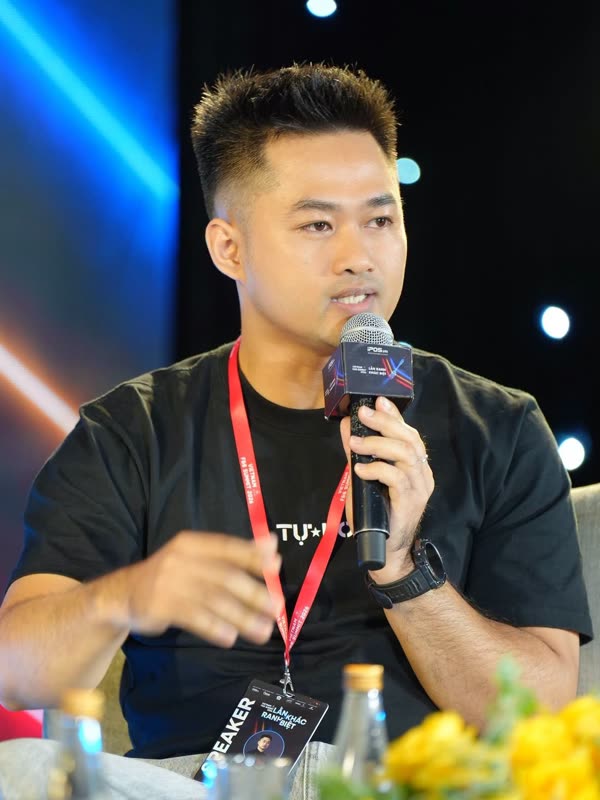 Đức Bùi cầm micro phát biểu, đeo thẻ diễn giả tại Vietnam F&B Summit 2026
